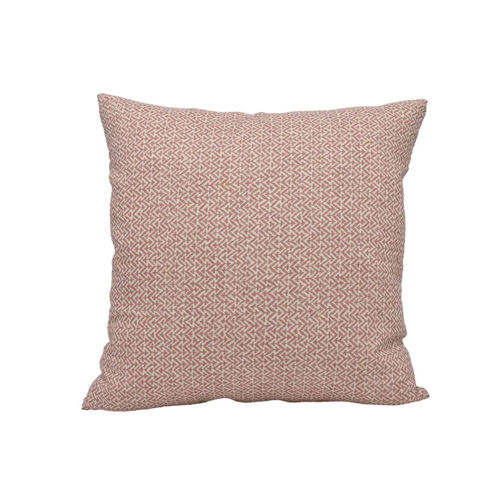 A single square pillow with a repeating pattern of pink and white geometric shapes.