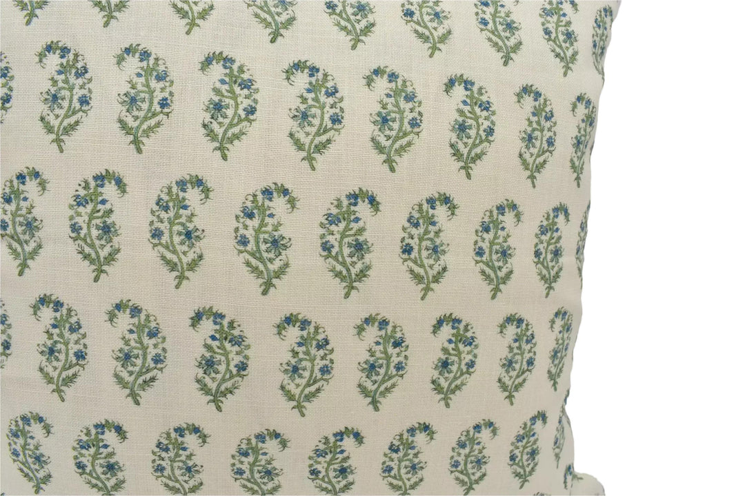 a close-up view of a beige fabric with a repeating pattern of green and blue floral designs.