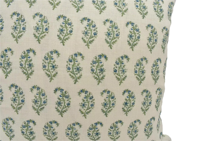 a close-up view of a beige fabric with a repeating pattern of green and blue floral designs.