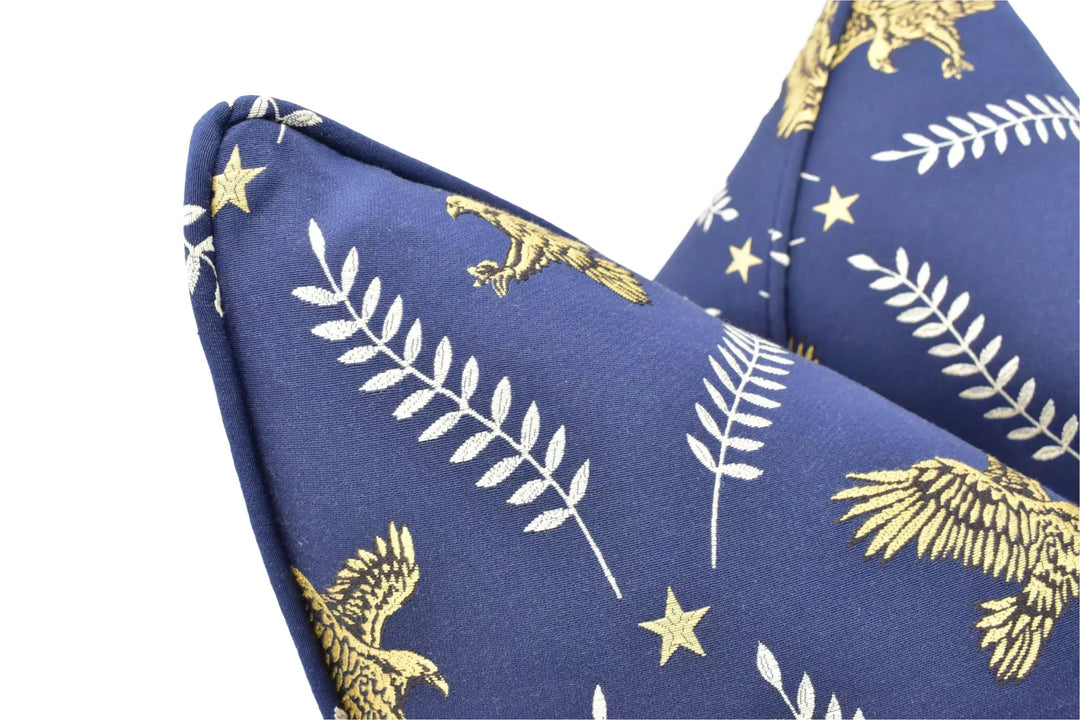a close-up view of a blue fabric with a gold eagle and leaf pattern.