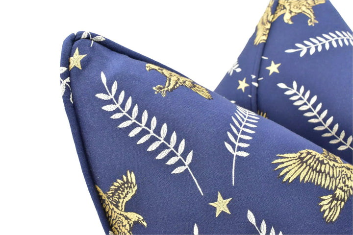 a close-up view of a blue fabric with a gold eagle and leaf pattern.