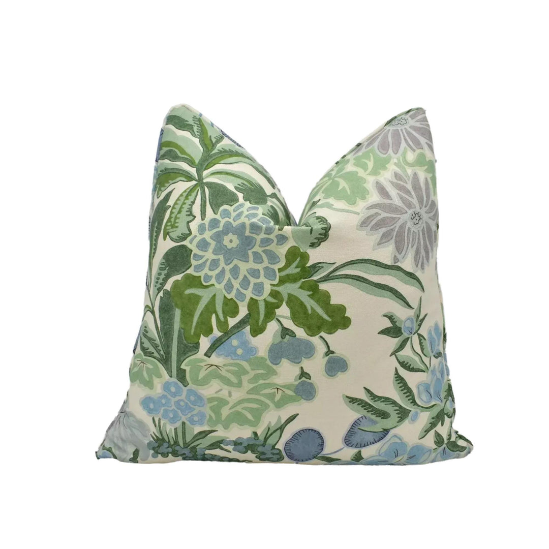 a decorative pillow with a floral pattern in shades of green and blue.
