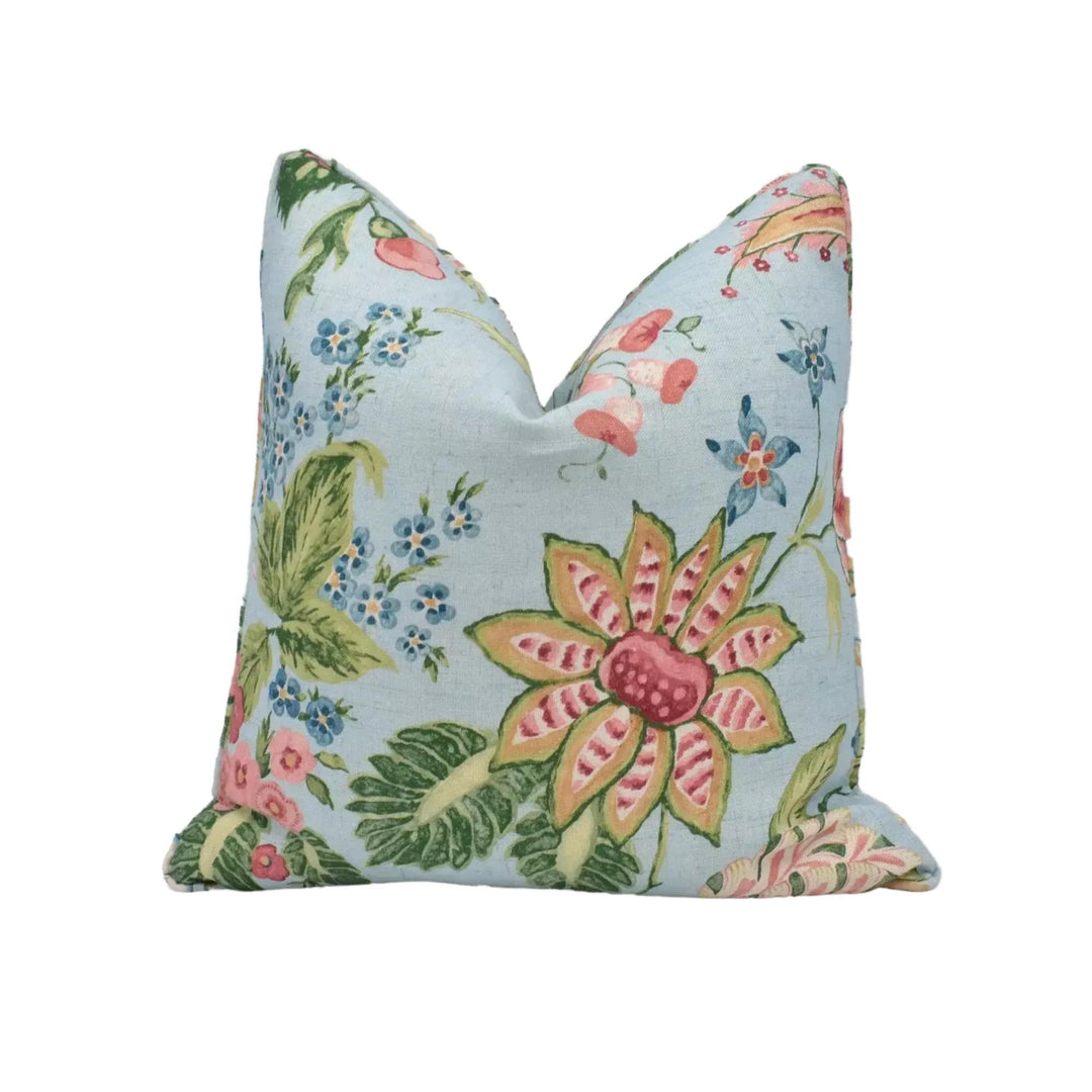 A decorative pillow with a floral pattern in shades of blue, pink, and green.