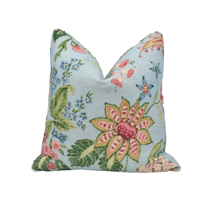 A decorative pillow with a floral pattern in shades of blue, pink, and green.