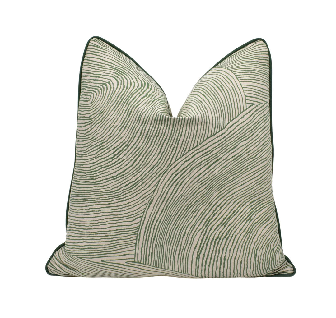 a green and white pillow on a white background