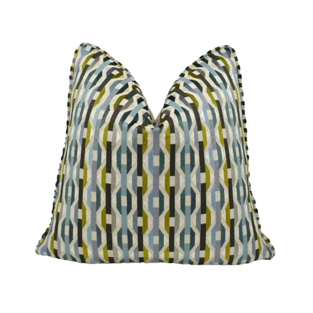 a decorative pillow with a geometric pattern in shades of blue, green, and gray.