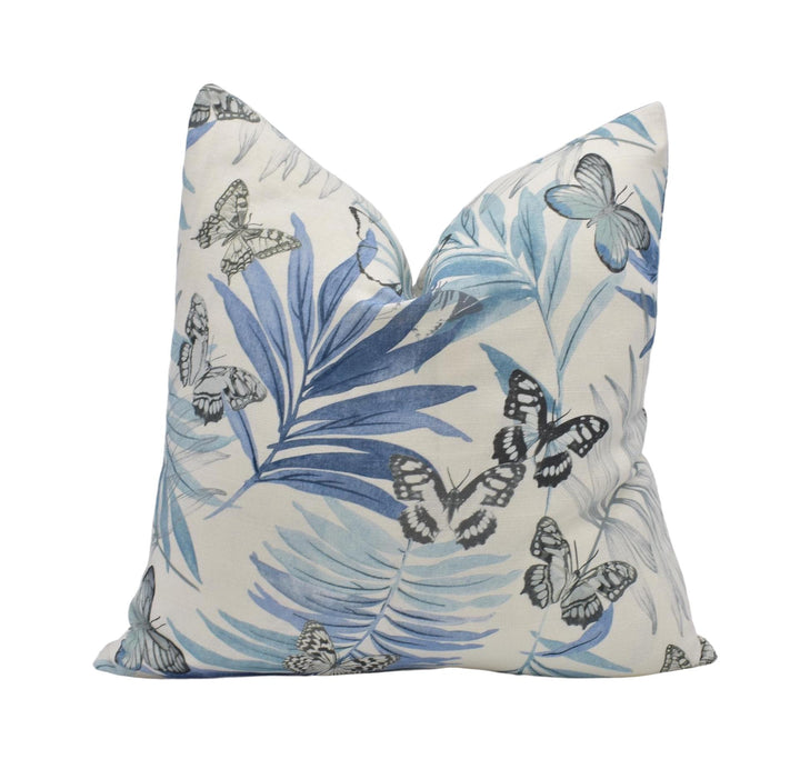 a decorative pillow with a blue and white butterfly pattern.