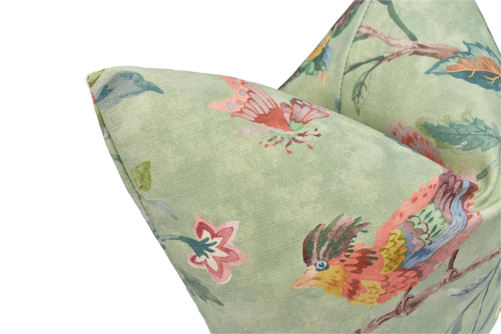 a close-up view of a green fabric with a vibrant, colorful bird and flower pattern.