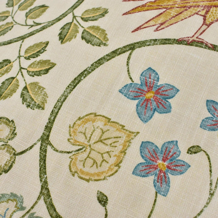 a close-up view of a fabric with a floral pattern, including leaves, flowers, and a bird.