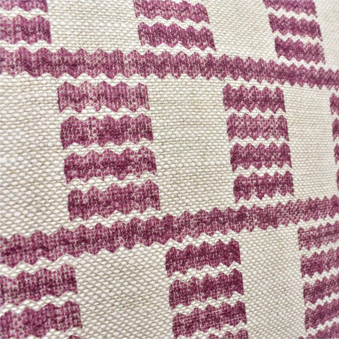 a close-up view of a fabric with a repeating pattern of pink and white stripes or lines. The pattern is composed of small squares or rectangles, creating a checkered or grid-like design. The fabric appears to be made of a woven material, with a textured and textured appearance.