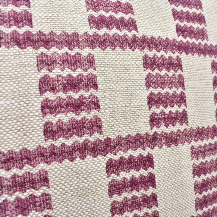 a close-up view of a fabric with a repeating pattern of pink and white stripes or lines. The pattern is composed of small squares or rectangles, creating a checkered or grid-like design. The fabric appears to be made of a woven material, with a textured and textured appearance.