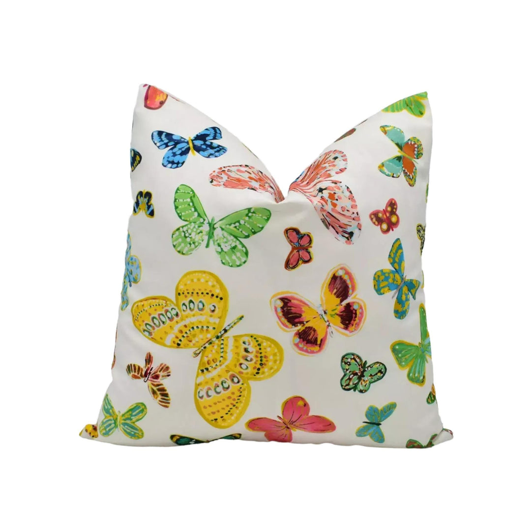 A white pillow with a vibrant and colorful butterfly pattern printed on it.