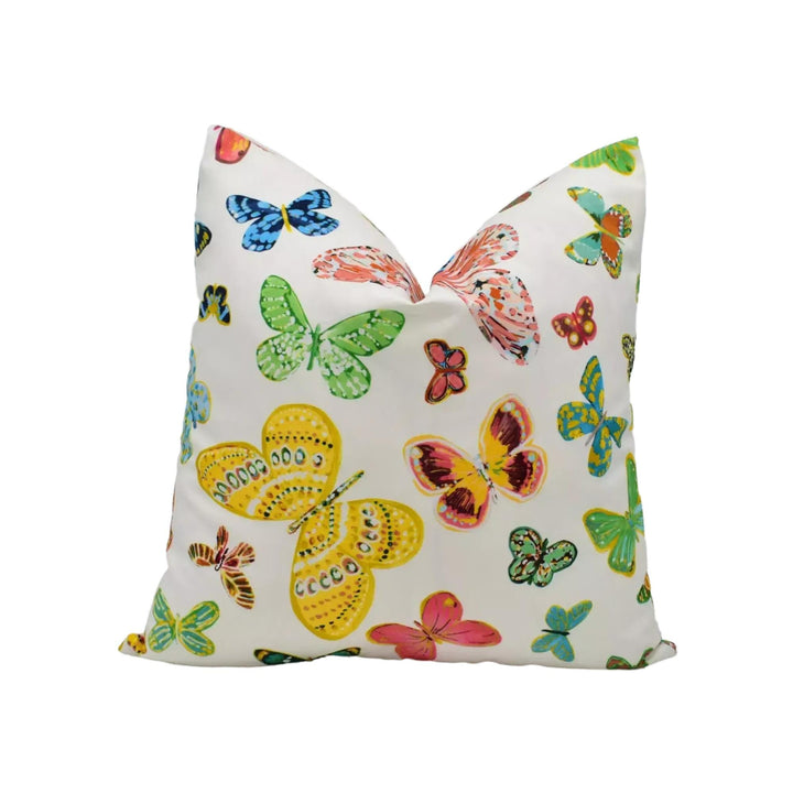 A white pillow with a vibrant and colorful butterfly pattern printed on it.