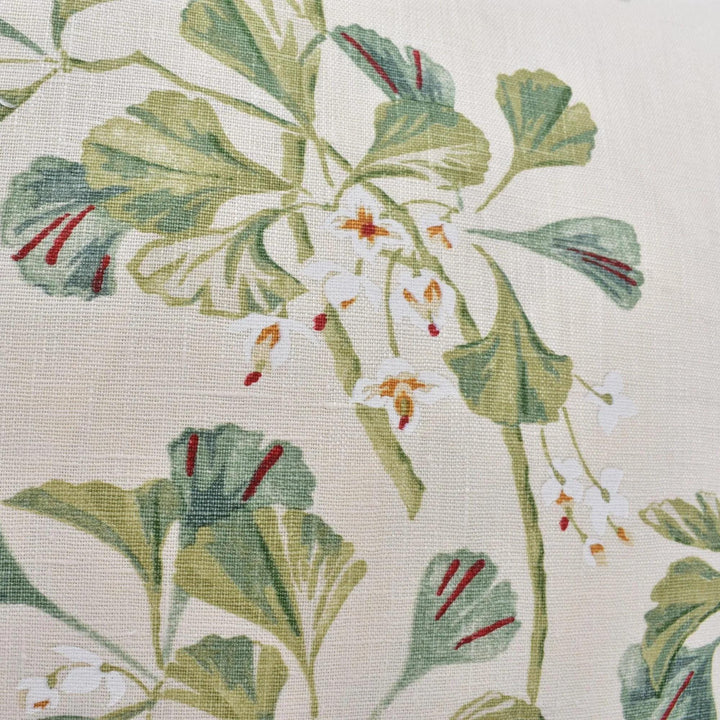 a close-up view of a fabric with a floral pattern. The pattern consists of green leaves and white flowers, creating a visually appealing and intricate design.