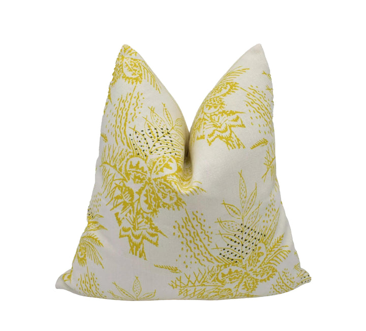 a white pillow with a yellow floral pattern.