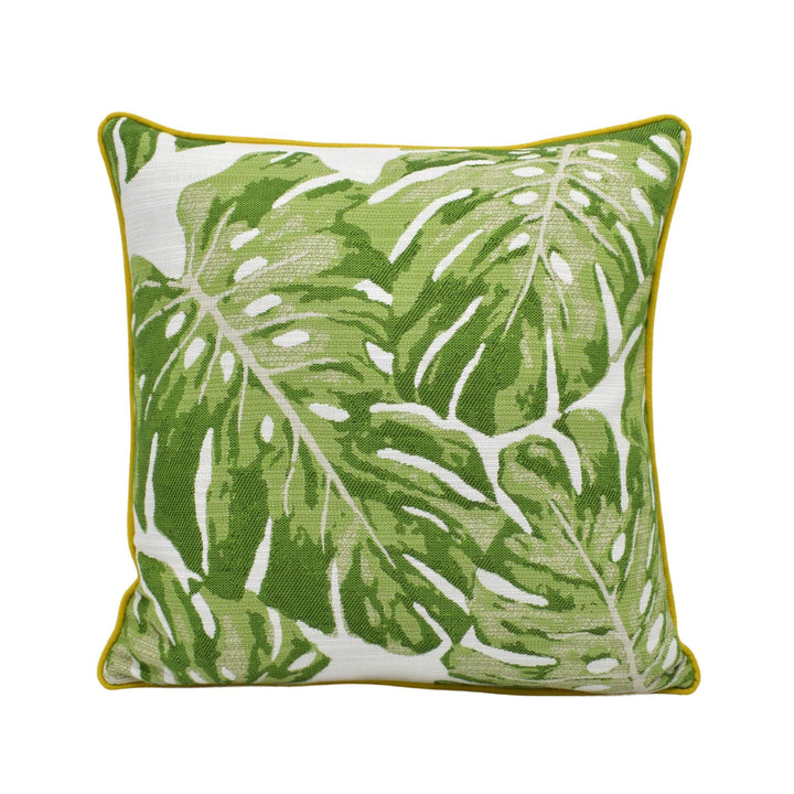 A square throw pillow with a green and white tropical leaf pattern.