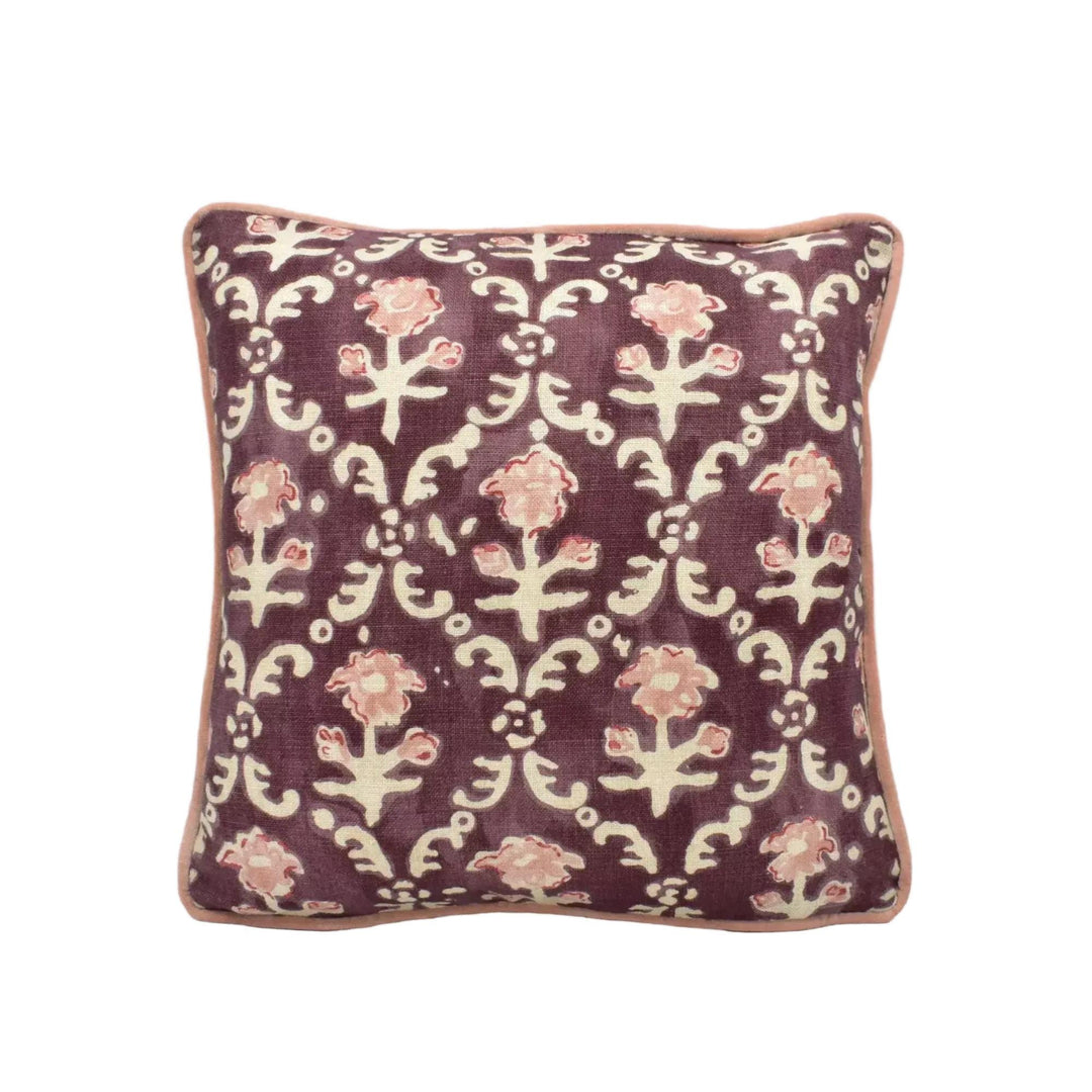 A square throw pillow with a floral pattern in shades of purple and white.