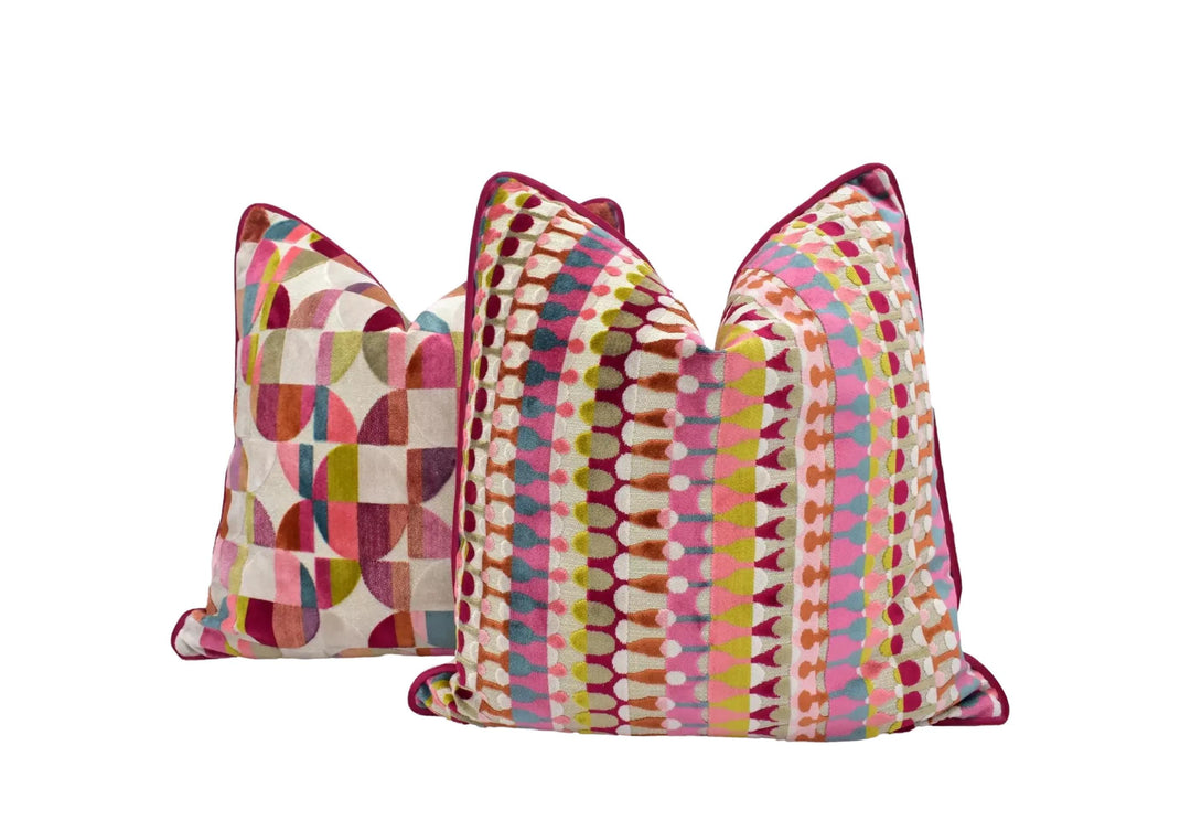 three colorful, patterned pillows with different geometric designs and vibrant colors.