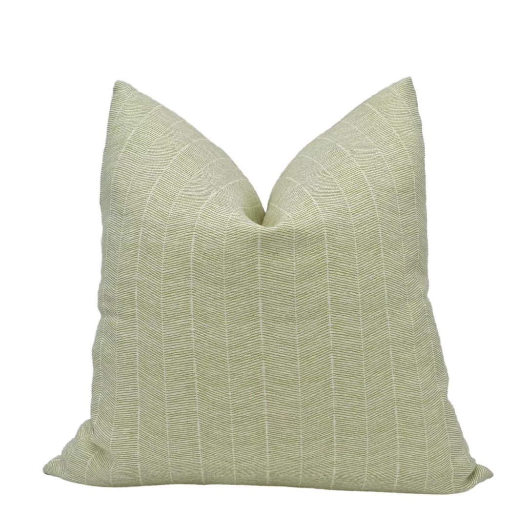 A single, light green throw pillow with a striped pattern.
