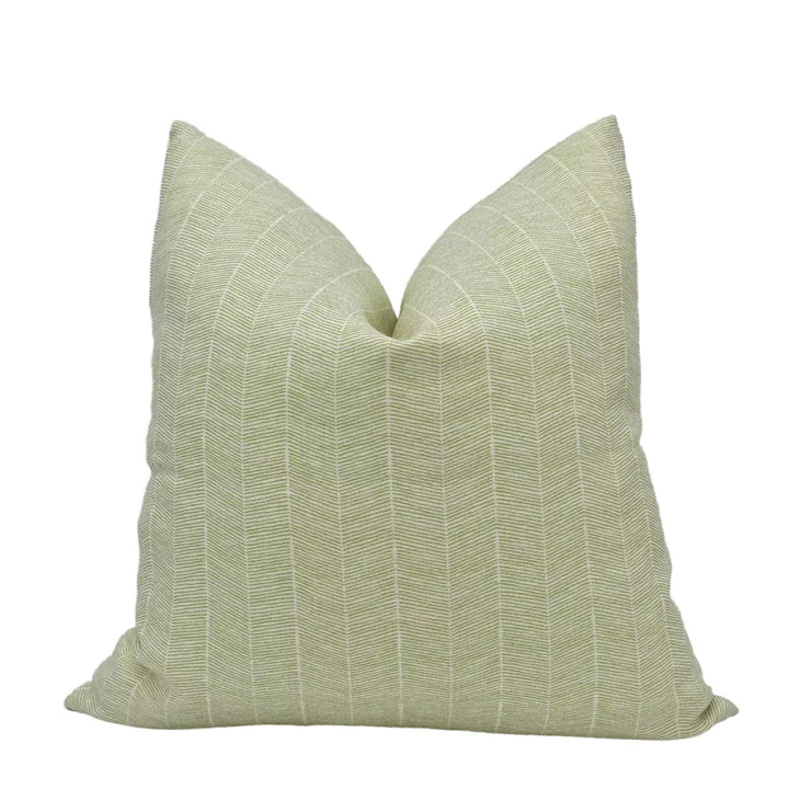 A single, light green throw pillow with a striped pattern.