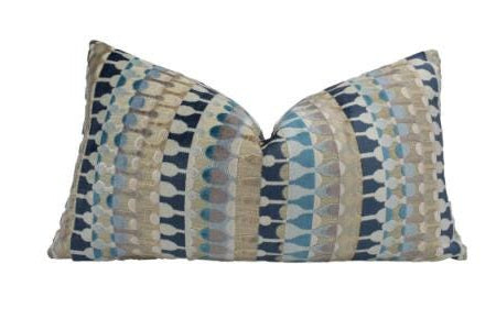 A decorative throw pillow with a geometric pattern in shades of blue and gray.