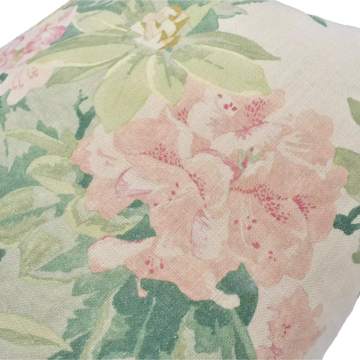 a close-up view of a fabric with a floral pattern, featuring a large pink flower surrounded by smaller pink flowers and green leaves.