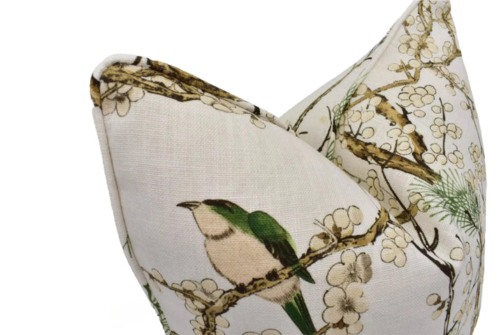 A close-up image of a white fabric with a floral pattern, featuring a bird perched on a branch.