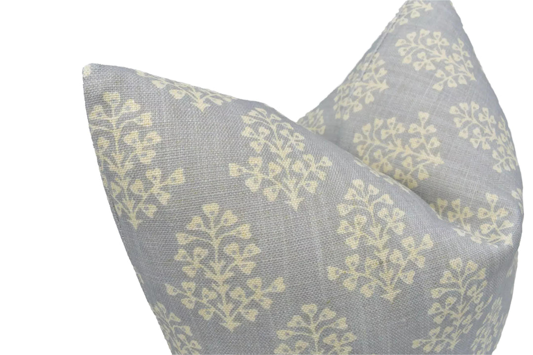a close-up view of a gray and white patterned pillow with a repeating tree-like design.
