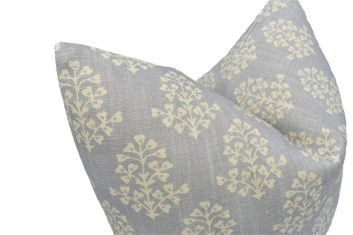 a close-up view of a gray and white patterned pillow with a repeating tree-like design.