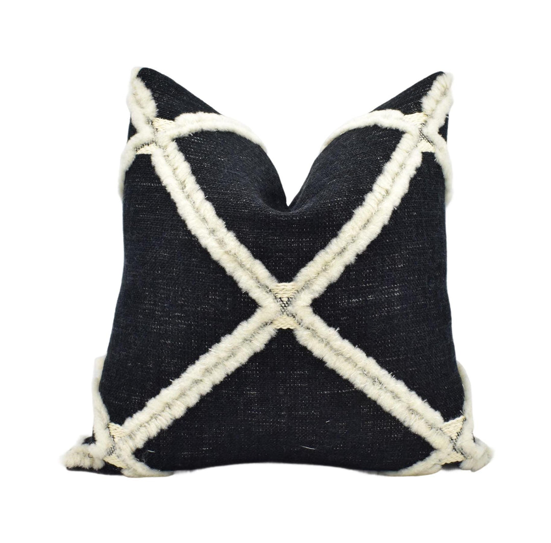 A black and white pillow with a distinctive white cross pattern on it.