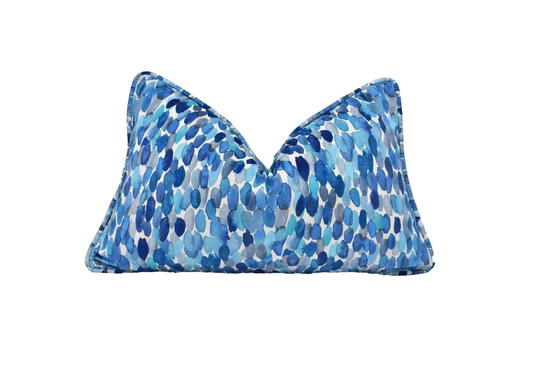 A blue and white patterned pillow with a watercolor-like design.