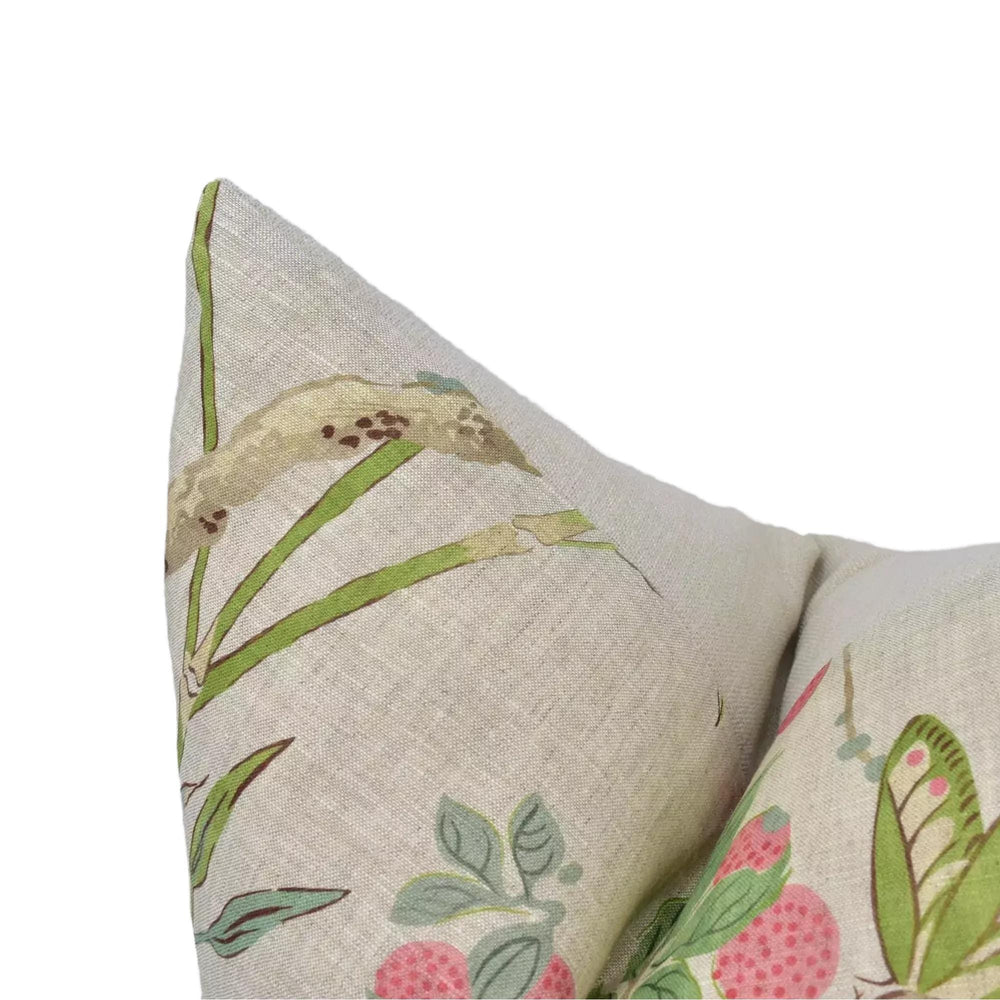 a close-up view of a beige fabric with a floral pattern, featuring a green leaf and a pink flower design.