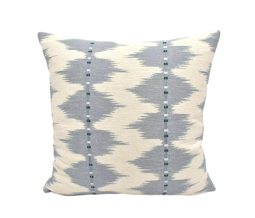 A square throw pillow with a gray and white geometric pattern, featuring vertical lines and small dots.