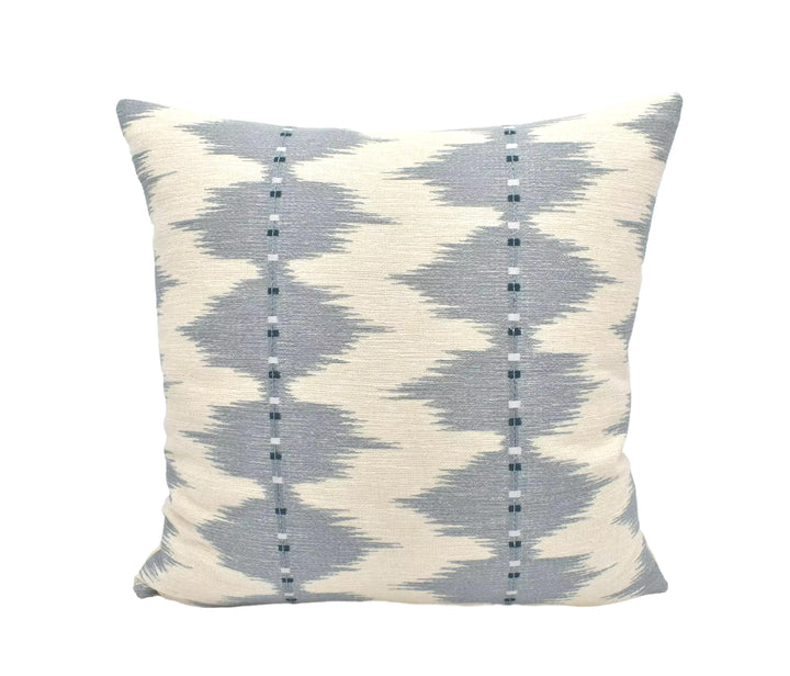 A square throw pillow with a gray and white geometric pattern, featuring vertical lines and small dots.