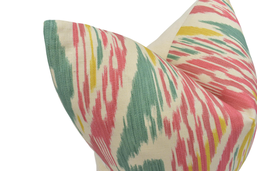 a close-up view of a colorful, patterned pillow with a vibrant mix of pink, green, and yellow colors.