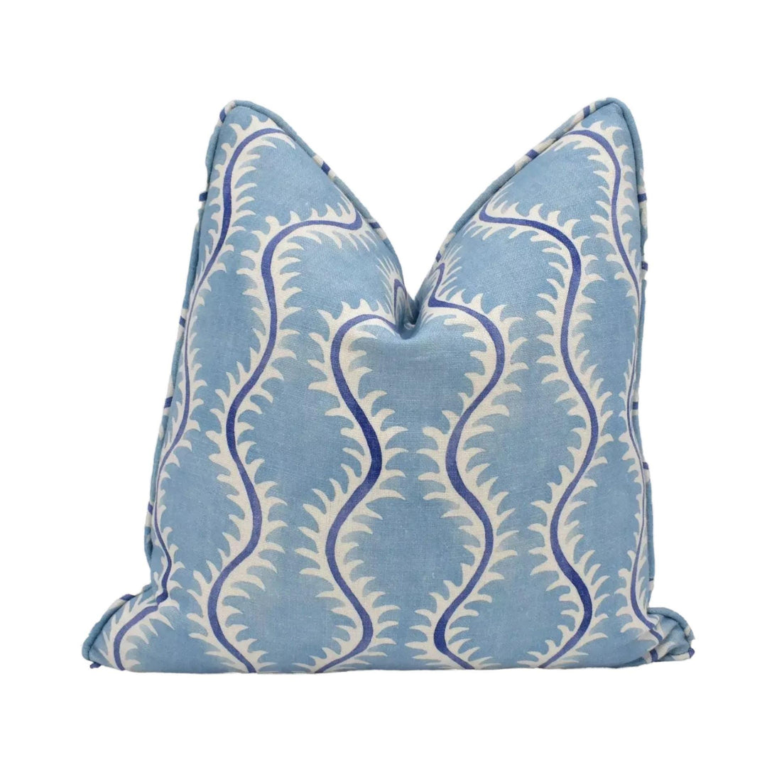 A blue and white patterned pillow with a repeating design of curved lines and leaves.