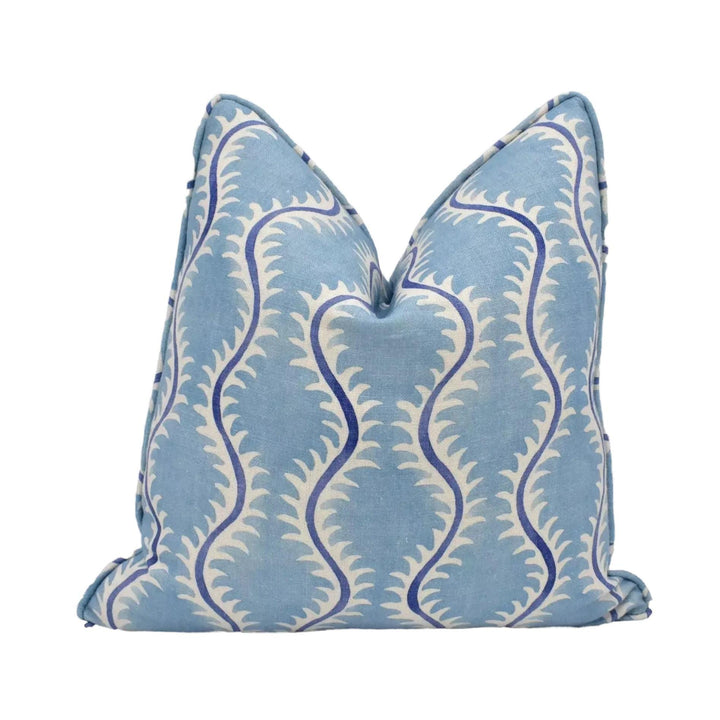 A blue and white patterned pillow with a repeating design of curved lines and leaves.