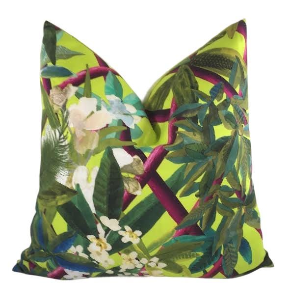a green pillow with flowers and leaves on it