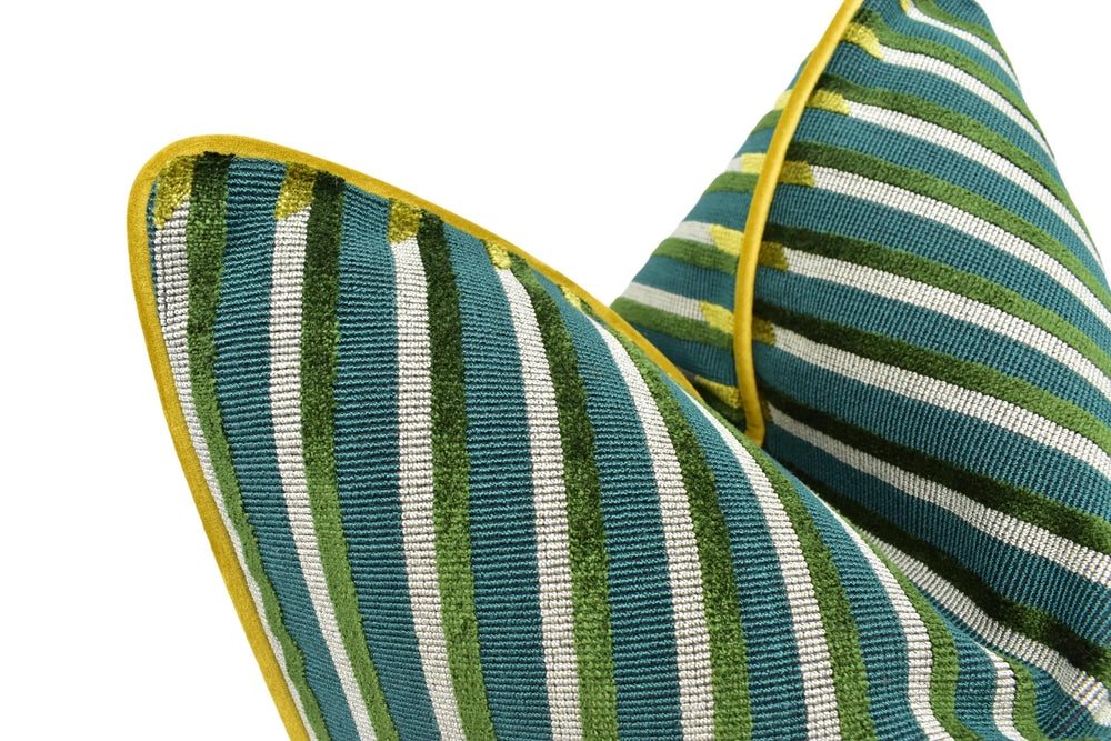 a close-up view of two pillows with a striped pattern in shades of green and white. The pillows have a pointed shape and a yellow border, creating a visually striking contrast against the white background.