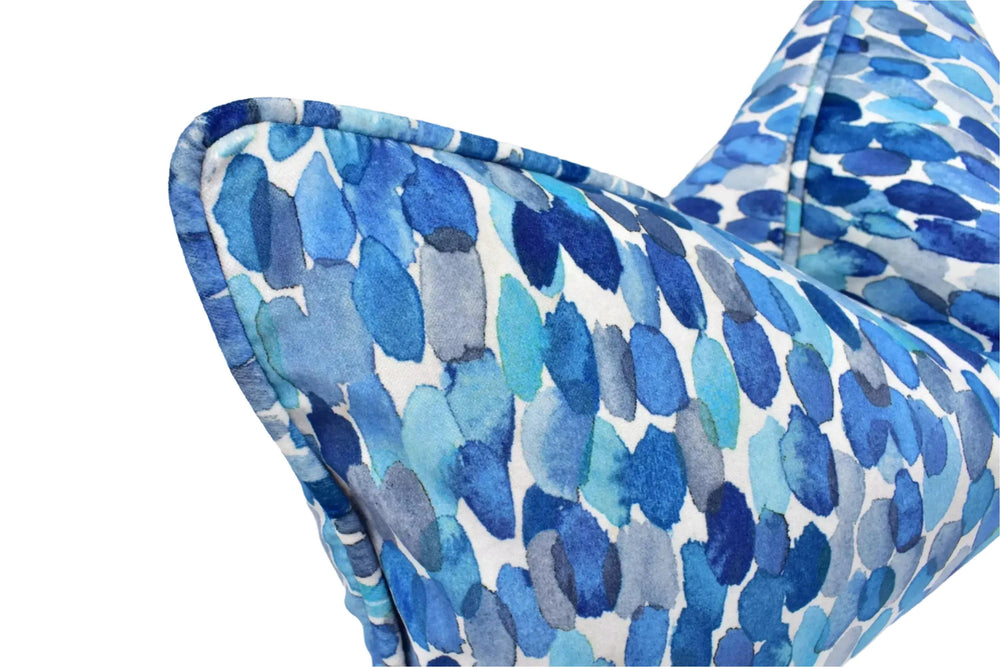 a close-up view of a blue and white patterned pillow or cushion with a watercolor-like texture.