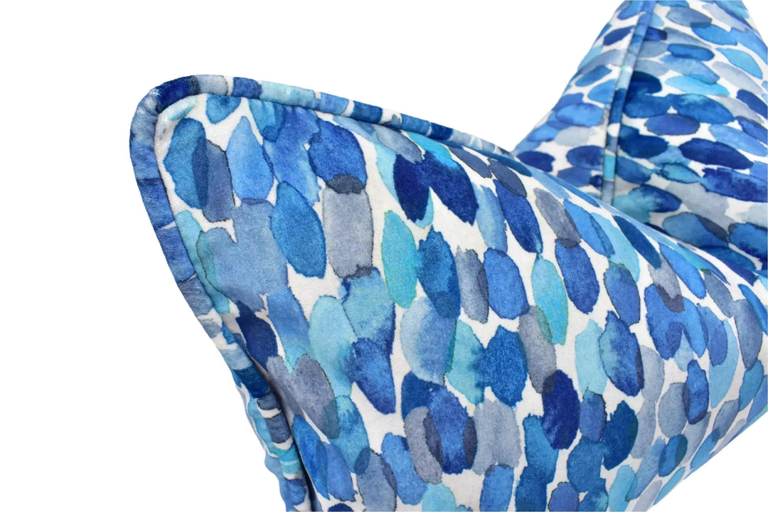 a close-up view of a blue and white patterned pillow or cushion with a watercolor-like texture.