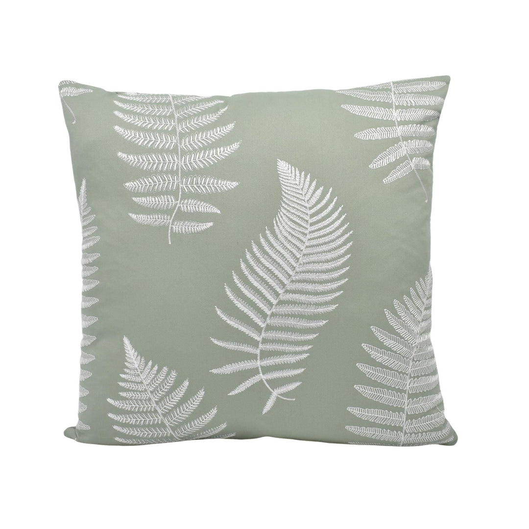 A square throw pillow with a repeating pattern of white fern leaves against a light green background.