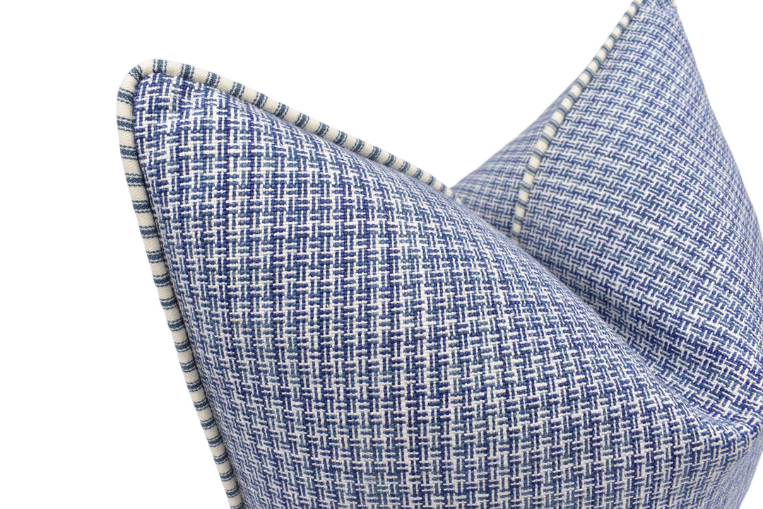 A close-up view of a blue and white woven pillow with a textured pattern.