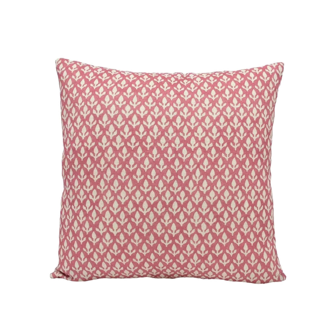 A square throw pillow with a repeating pattern of pink and white flowers or leaves.