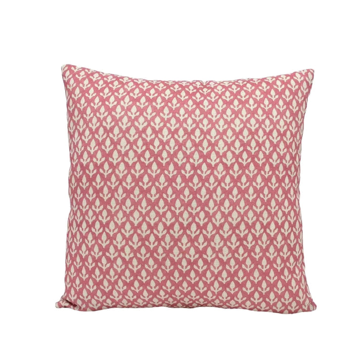 A square throw pillow with a repeating pattern of pink and white flowers or leaves.