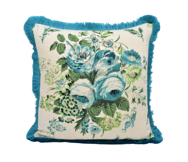 A decorative throw pillow with a floral print and a blue fringe border.