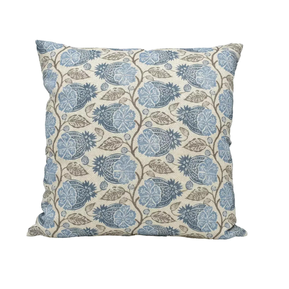 A square throw pillow with a repeating floral pattern in shades of blue and brown.
