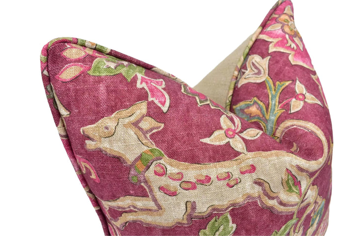 a close-up view of a decorative pillow with a vibrant floral pattern in shades of pink and red.