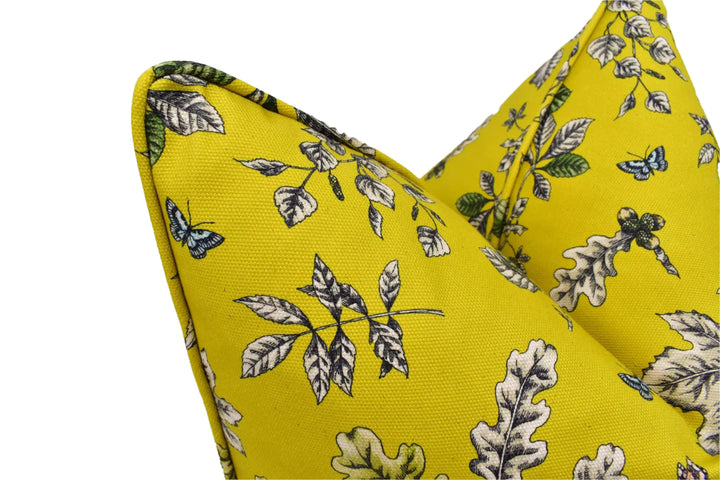 a close-up view of a yellow fabric with a leaf and butterfly pattern.