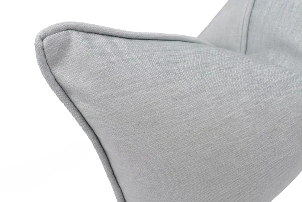 A close-up view of a gray fabric pillow, with a textured surface and a slight curve at the top.